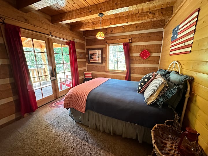 El dormitorio de invitados en el primer piso ofrece entrada privada, cama tamaño queen, armario, TV y techo de vigas de madera.