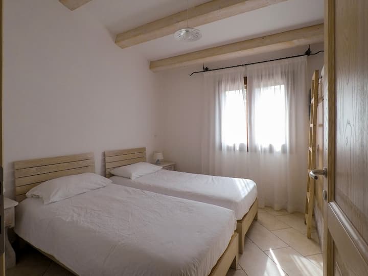 חדר שינה זוגי עם שתי מיטות יחיד ומיטת לופט אחת. 