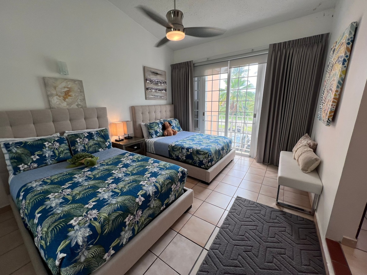 Chumba cha pili cha kulala chenye vitanda viwili vya starehe na milango ya glasi inayoteleza kwa ajili ya hewa safi