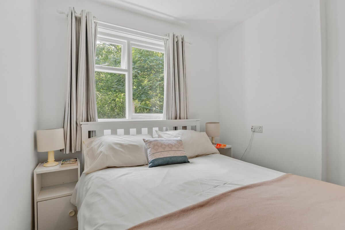 二号卧室，小屋后方的双人卧室，可俯瞰林地。 配备双人床、两张小床头柜和一张带镜门的单人衣柜。