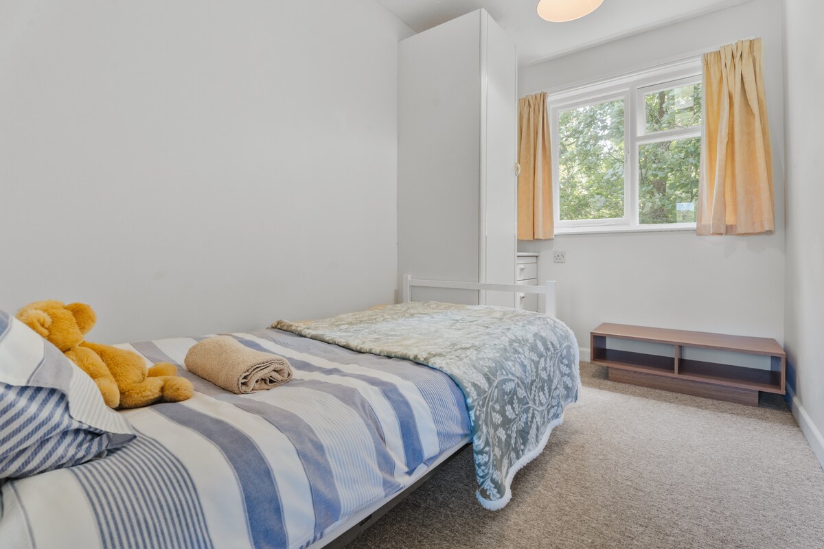 四号卧室，也位于房源后方，面向林地。 这间客房配有一张单人床、小衣柜和小抽屉。