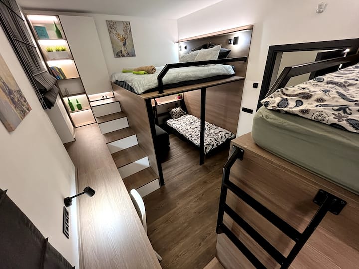 Dormitorio en planta baja con un total de 5 lugares para dormir: 2 en una cama doble, 2 debajo y otra cama individual en el nivel superior (accesible por una escalera de 4 escalones).
Este dormitorio tiene acceso directo al inodoro al que se puede llegar a través de la sala de estar.