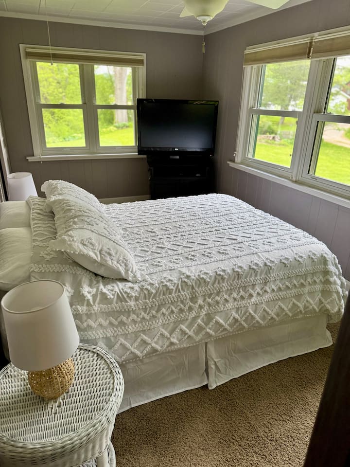 Спалната соба има поглед на езеро и преден двор. 