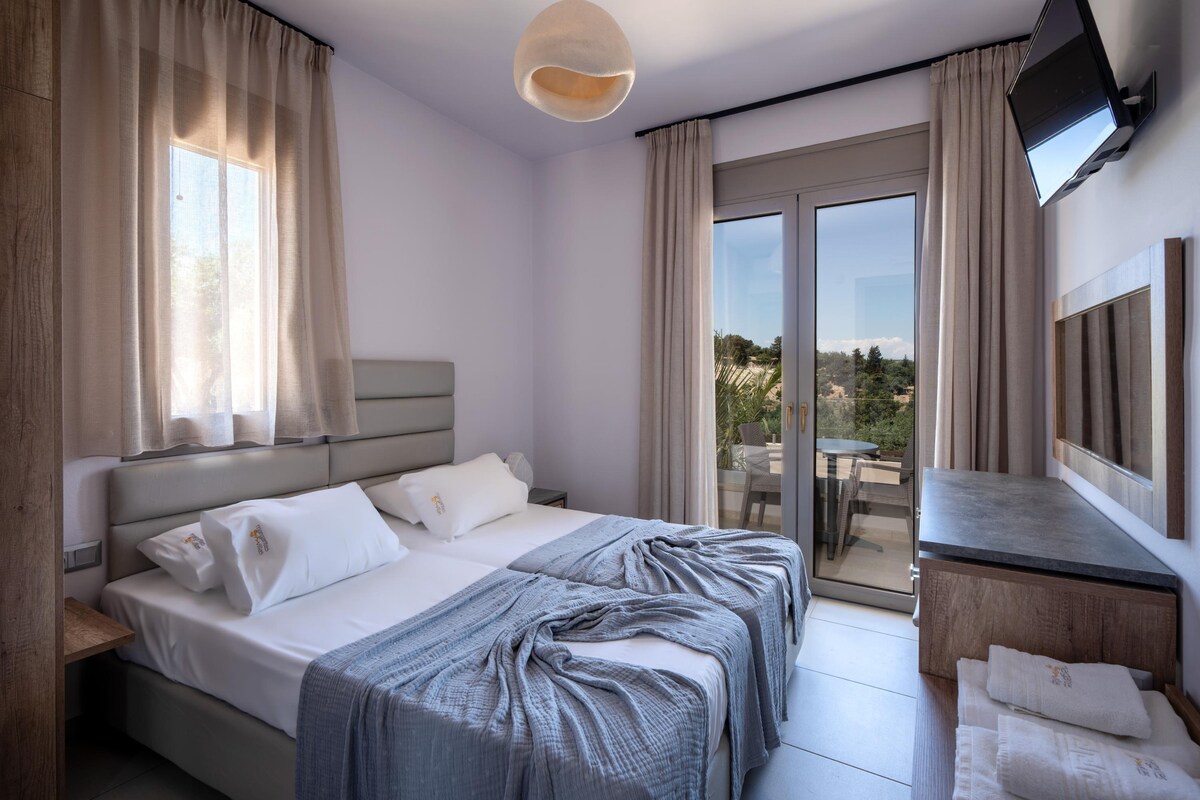 غرفة نوم في الطابق الأول مع غرفتين فرديتين ودش داخلي وشرفة للجلوس.