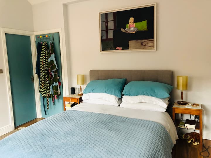 Cama tamaño king, lámparas de noche y enchufes para cargar el teléfono.