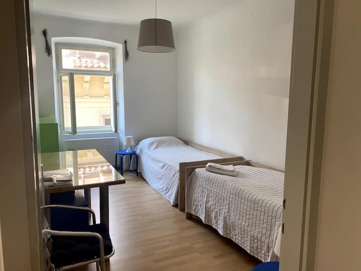 Საძინებელი 2 ორი ერთადგილიანი საწოლით, მაგიდით და სკამით, ფანჯარა ხეივნისკენ, საიდანაც ზღვის ხედი იშლება