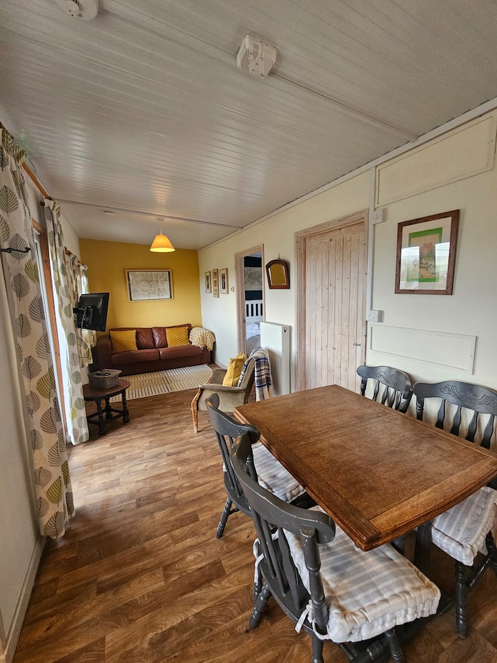 Sala de estar/comedor/cocina de planta abierta con televisión y amplias vistas