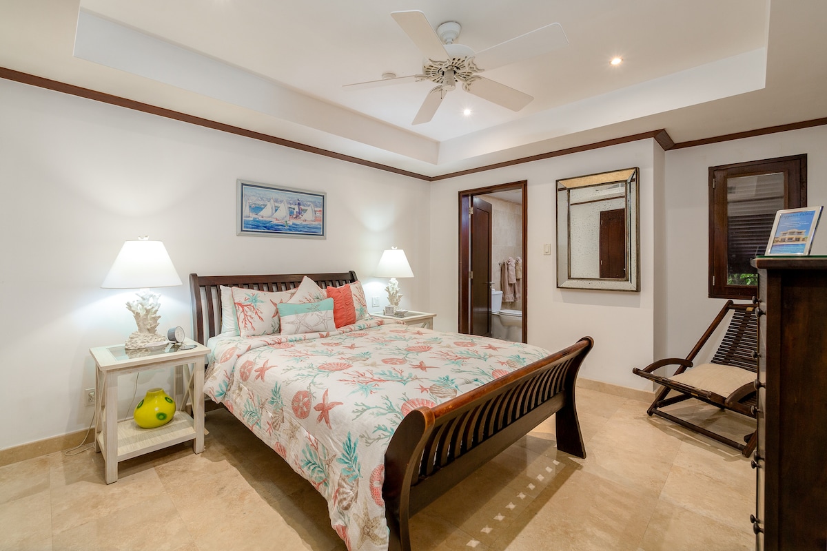 La chambre 2 est une chambre bien aménagée avec un lit Queen size, la climatisation, un ventilateur de plafond, une télévision intelligente, une armoire et des tiroirs et une salle de bain attenante.