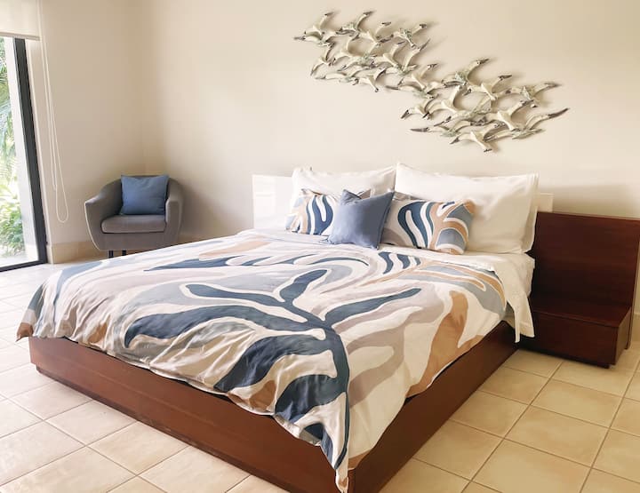 Dormitorio principal con cama tamaño king y vistas a la terraza.