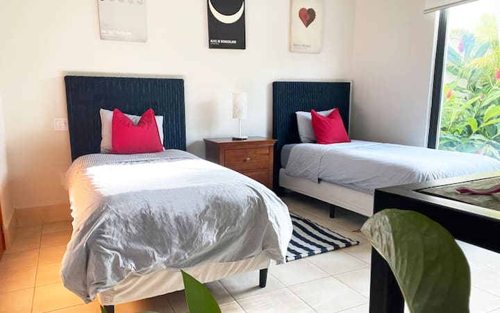 Tercera habitación bien decorada con dos camas individuales y con vistas a la terraza.