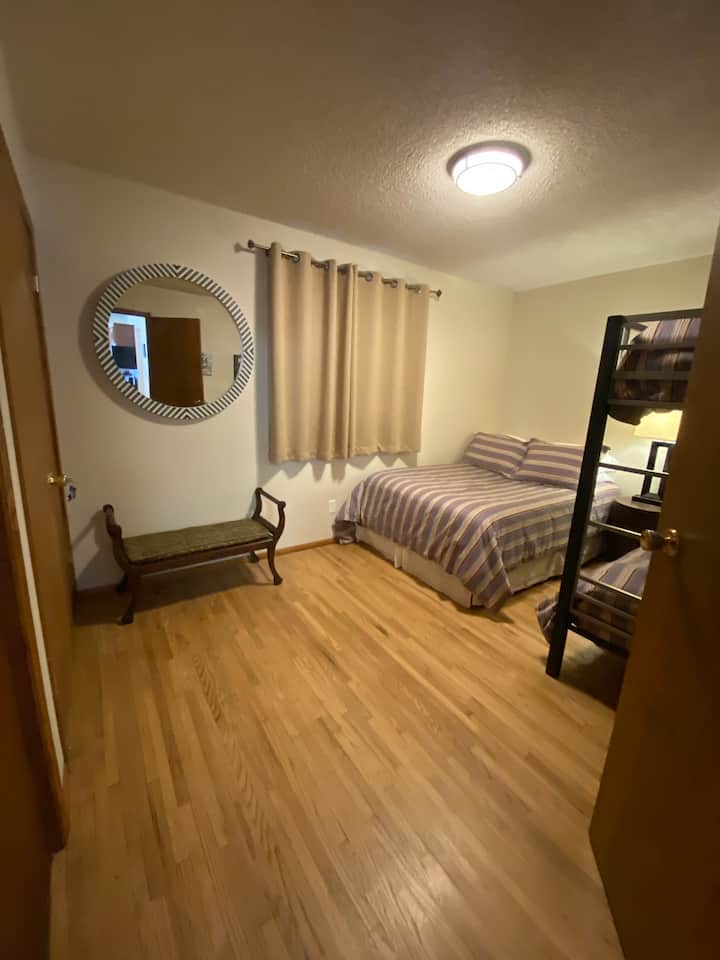 חדר שינה למטה עם מיטה מלאה אחת, סט אחד של מיטות זוגיות. 