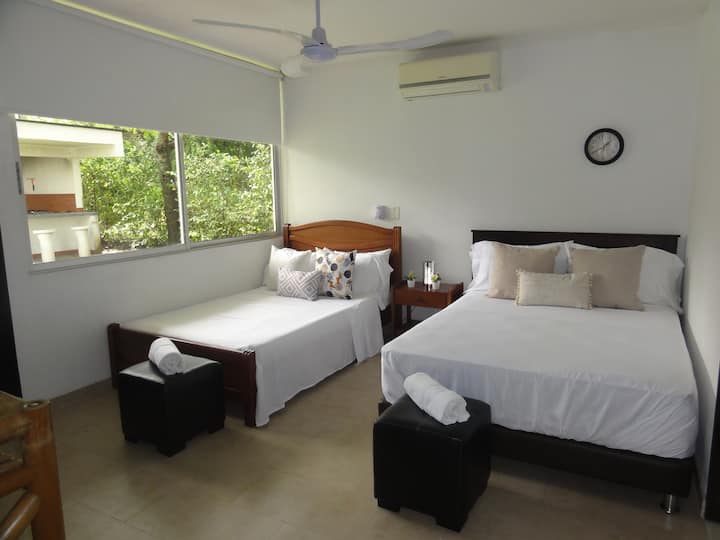Comfortable fourth alcove, with double bed, semi double bed, air conditioning, private bathroom, TV, fan, black out curtain, white linen, private bathroom and view towards the BBQ area.