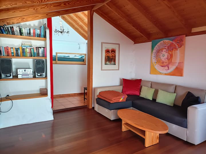 Wohnbereich mit geöffneten Vorhang, Blick in den Schlafbereich.