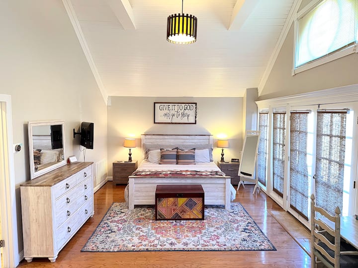 غرفة نوم رئيسية مع أسقف مقببة، 8 نوافذ كبيرة تسمح بدخول ضوء طبيعي وافر. سرير بحجم كينج مع مرتبة Tempur - Pedic وطاولات جانبية وتلفزيون وخزانة ملابس مكونة من 6 أدراج ومرآة كاملة الطول وحمام رئيسي خاص وإمكانية الوصول إلى فناء الفناء/الفناء الخلفي والمزيد!