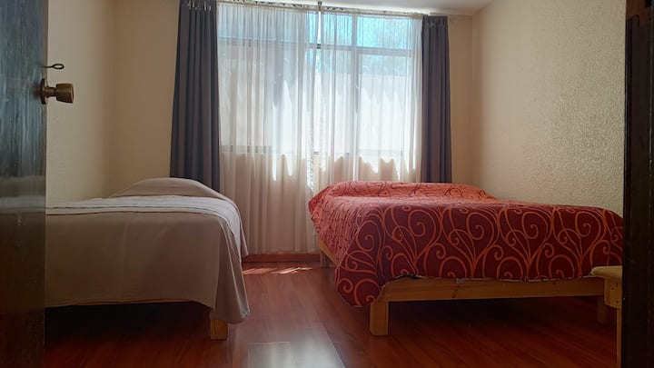 Dhomë e vendosur në katin përdhes të shtëpisë, ka një krevat dopio dhe një tek. Ka një banjë private.
