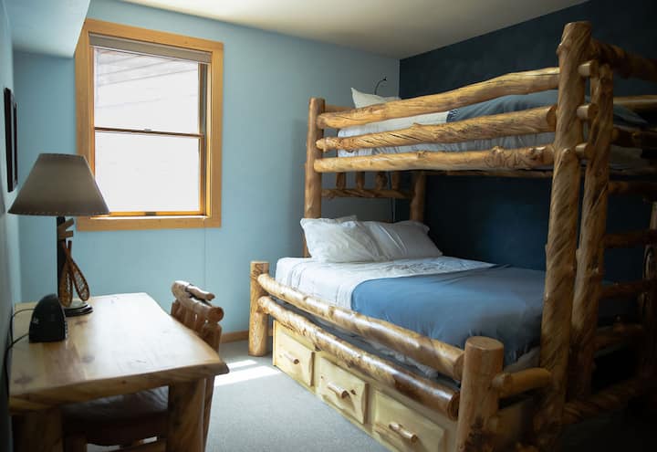 Kitanda cha ghorofa kilicho na malkia chini na mapacha juu. 