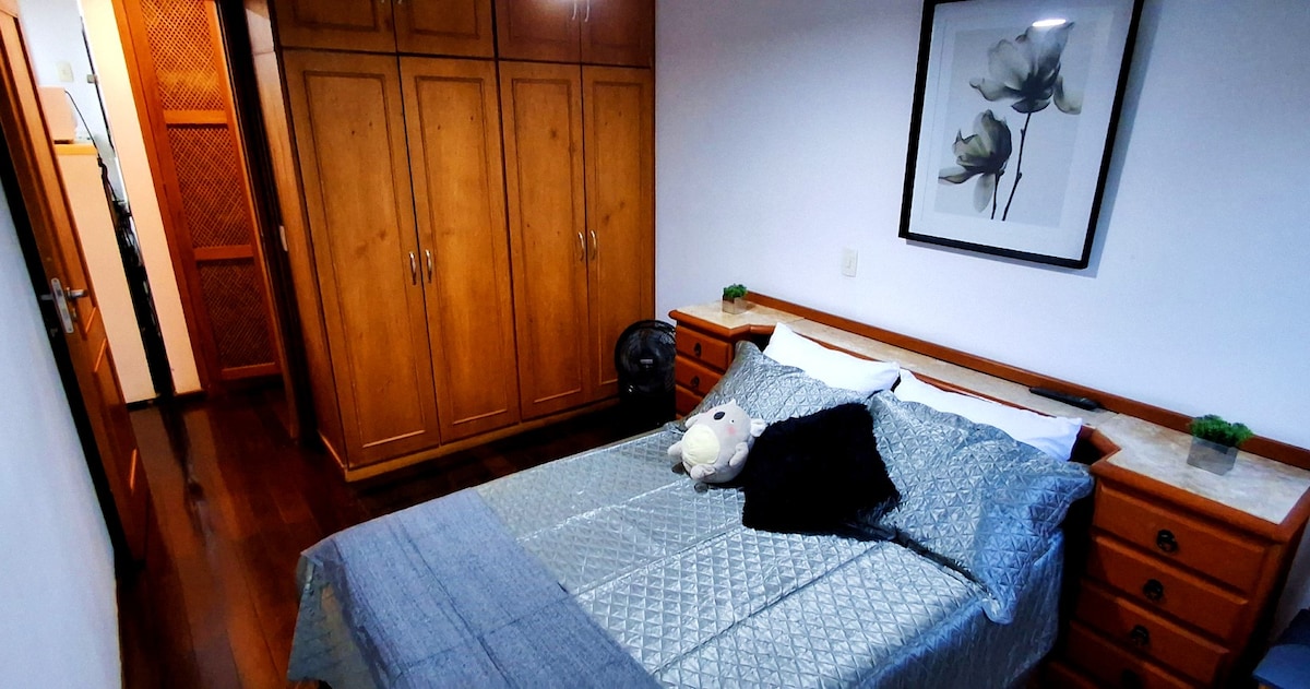 Chambre avec lit double, télévision par câble, placard, coffre-fort, climatisation et ventilateur.