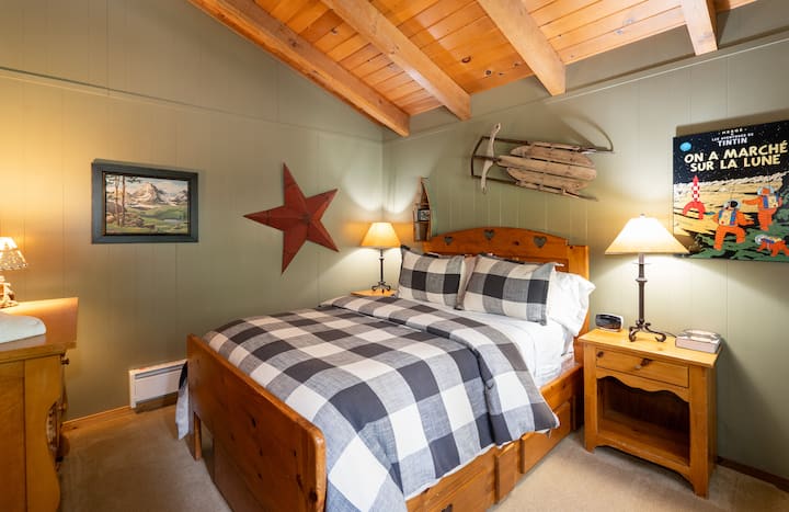 Upstairs bedroom #2 with pull out trundle underneath bed and view of backyard and hot tub. Down pillows.