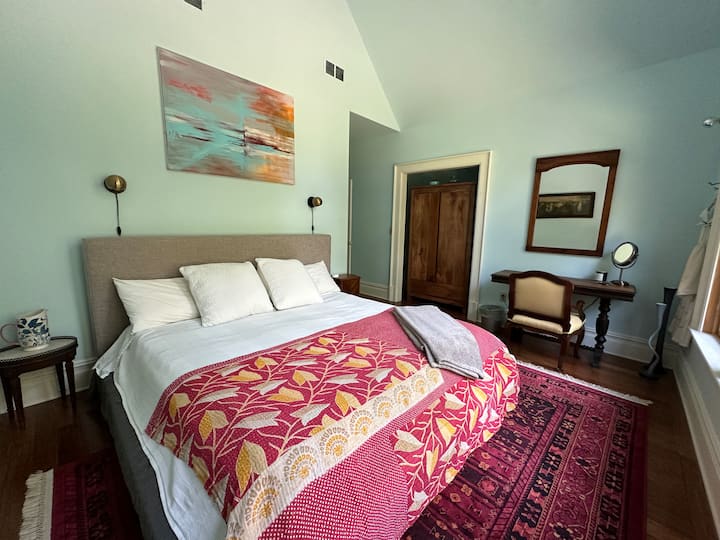 The Blue Room; big cozy king size bed, hardwood closet and small vintage work desk and mirror.