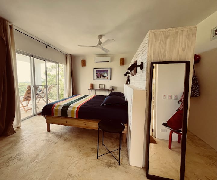 In een casita in het hart van de tropische tuin, met 180* uitzicht op de natuur met uitzicht op zee, slaapkamer met kingsize bed (mogelijkheid van "tweepersoonsbedden". Kantoorruimte (Starlink verbonden). Kleedkamer en aangrenzende badkamer. Airconditioning en ventilatoren