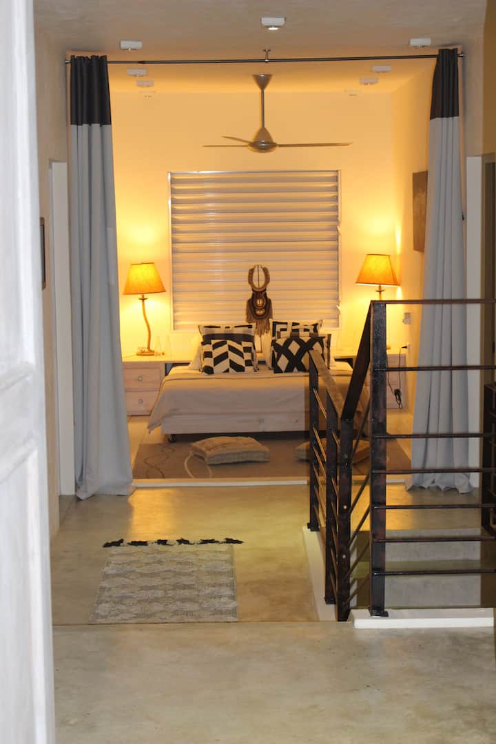 De ingang van het huis komt uit op een kleine lounge  die voor één persoon een extra slaapkamer kan worden, gesloten door gordijnen. Een luifel met zeezicht en plafondventilator zorgen voor een prachtige helderheid en goede ventilatie. 