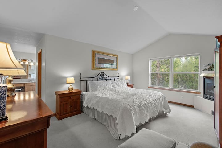 ห้องนอนหลักขนาดคิงไซส์สวยงามพร้อมเตาผิงสำหรับค่ำคืนที่อบอุ่น 