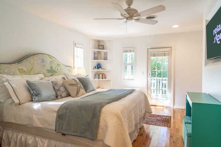 Dormitorio principal. Cama tamaño king de 76” X 80” con un baño: un lavamanos, una ducha, un inodoro y un armario.