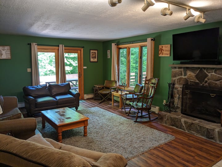 Sala de estar con chimenea, TV montada y acceso a la terraza.