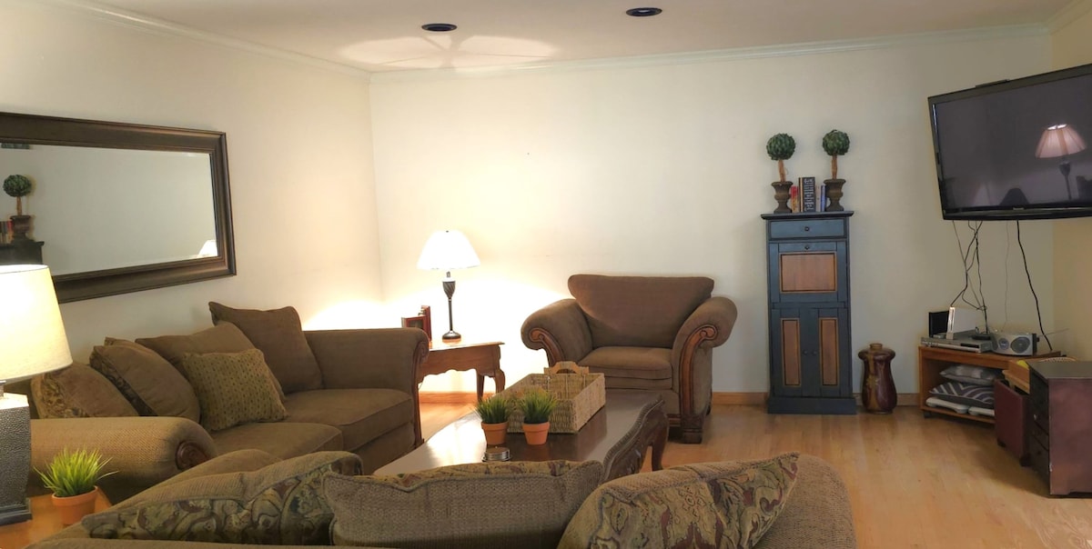 Sala de estar uno. Muchos asientos cómodos. La puerta corrediza conduce al porche con ping pong y juegos de patio. 