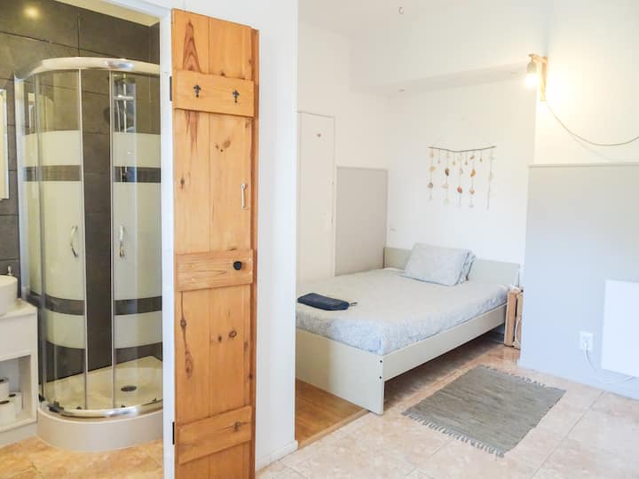 Ocean Suite's back bedroom with a double bed and en-suite bathroom, offering a comfortable and private space in the top-floor apartment. Bed linen and towels provided.
