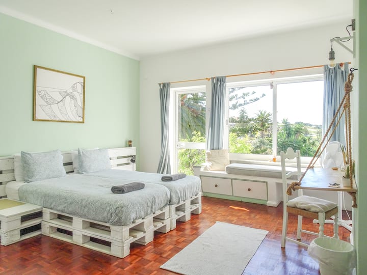 Ocean Suite's second bright & airy bedroom can be arranged into a queen bed or twin setup. Large windows frame garden and sea views, and French doors lead to a private balconette shared with the Master bedroom.
