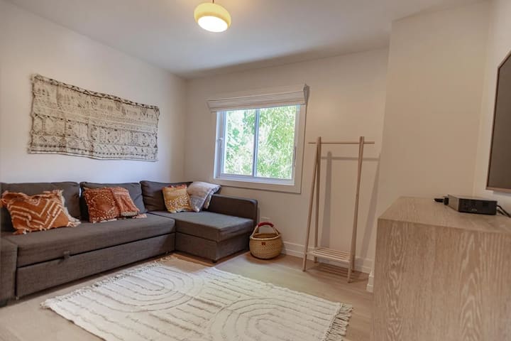 Телевизионна зала с 55 - инчов телевизор Samsung Frame. Диванът се разгъва до пълно легло. Спалното бельо е в секцията за шезлонги. 