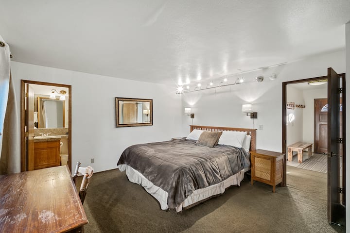 חדר שינה ראשי קווין הממוקם ממש מחוץ לכניסה בקומה התחתונה, עם תאורה נהדרת, שולחן לנוחות נוספת וחלון גדול שמאפשר הרבה אור טבעי.