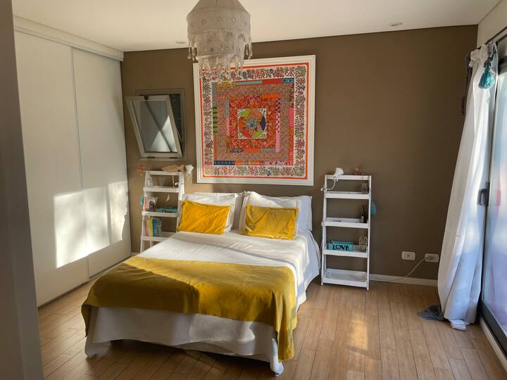 主臥室位於樓上，配有套房浴室、雙人床和床頭櫃