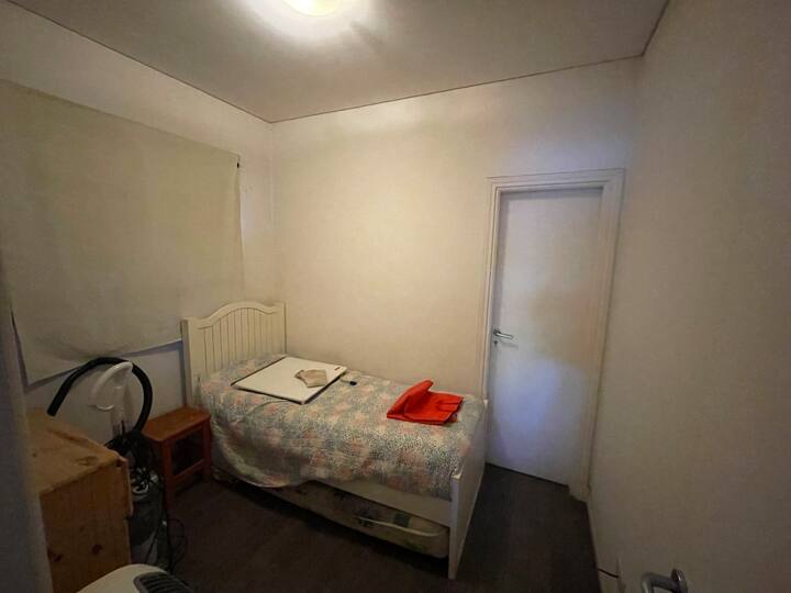 這是一間簡易臥室，位於一樓，介於洗衣房和泳池浴室之間，兼具服務浴室和泳池的雙重功能（雙入口）。