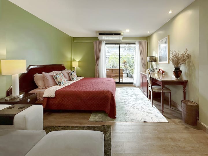 Indulge in our master bedroom. Featuring a large, comfortable king bed with premium linens. The room offers a private balcony view, a dedicated wooden work desk, and ample natural light. Designed for ultimate relaxation after a day of exploring