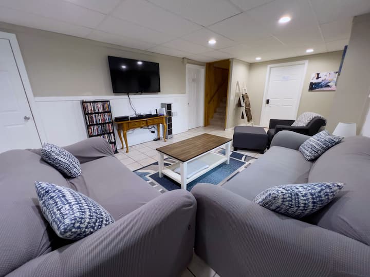 Sehemu ya chini ya kuishi, televisheni ya "55" iliyo na kicheza Blu-ray na mkusanyiko wa DVD.