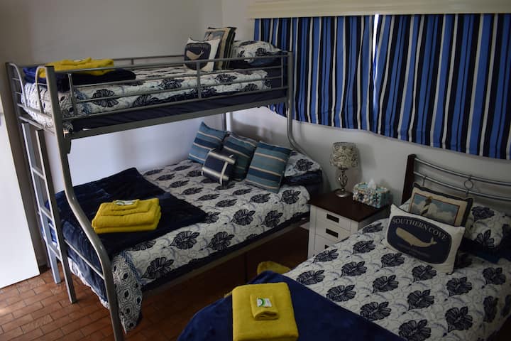 חדר שינה  3 מיטות זוגיות כפולות בתחתית, מיטת יחיד למעלה ומיטת יחיד.