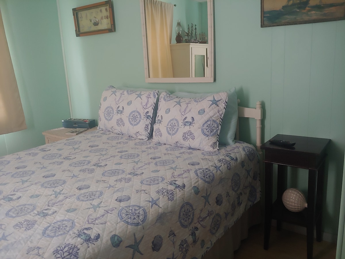 Sail boat room with antique mirrored armoire, dresser, and closet.
