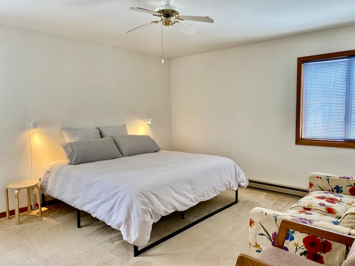 Habitación amplia con cama tamaño king, sofá cama y espacio de trabajo