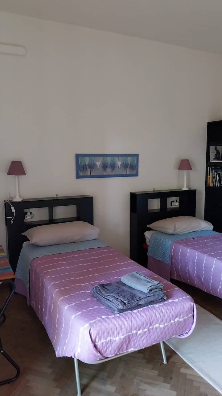 Second bedroom with two single beds. This room also has access to the balcony overlooking the town of Rho. Very large closet. In each room there is a workstation with a desk.