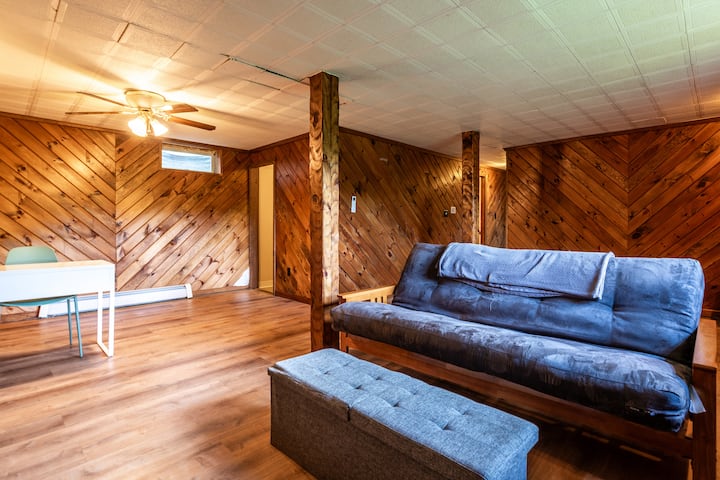 Sala ricreativa al piano inferiore, dotata di un comodo futon completo, TV HD, scrivania e sedia. La lavanderia è accessibile da questa zona.