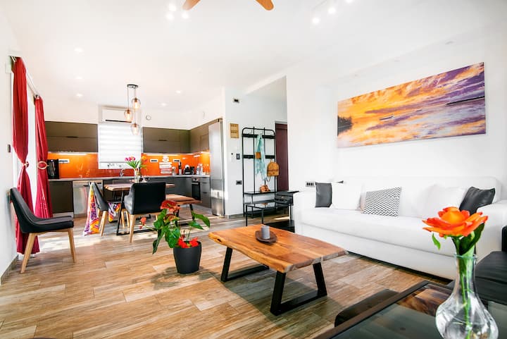 Luminosa sala de estar de planta abierta con cocina totalmente equipada y zona de comedor, perfecta para pasar tiempo juntos después de un día fuera.