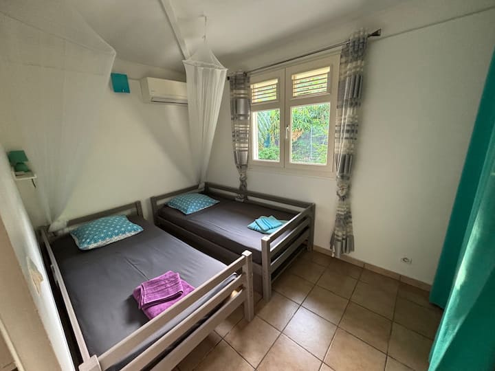 一楼的第三间卧室： 2张90 x 190厘米的床。
空调和蚊帐
大更衣室
可欣赏后花园景观的窗户（香蕉树）