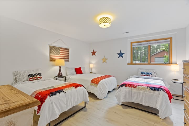 低层卧室，配备两张单人床、一张双人床和平板电视