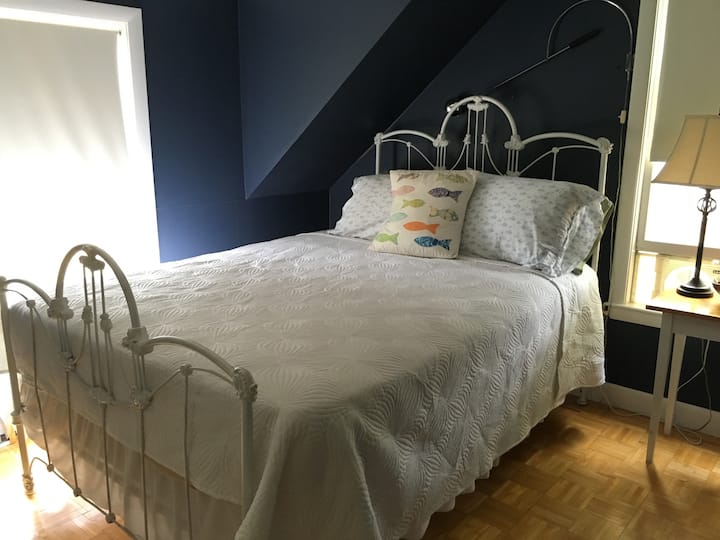 Dormitorio acogedor y atractivo con una cómoda cama tamaño queen, una suave luz natural y una encantadora decoración costera. Un espacio tranquilo para relajarse y recargar energías después de un día de playa.