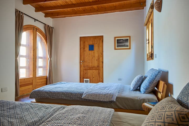 Andra sovrummet med två enkelsängar. Utsikt mot verandadörren och dörren mot sovrummet.