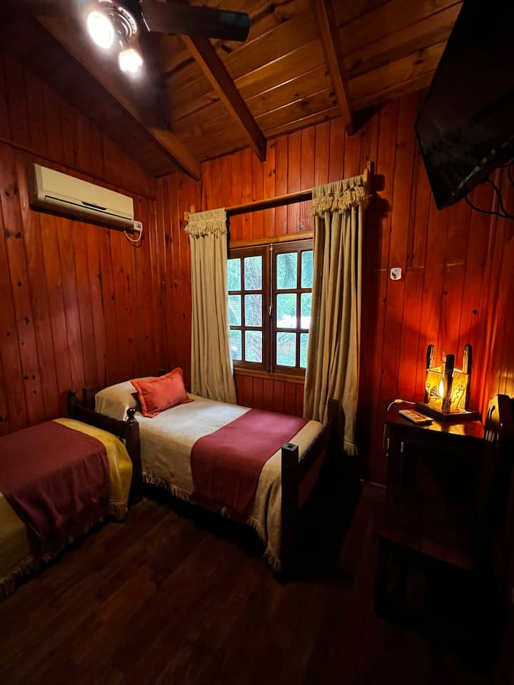 غرفة بسريرين مفردين وتلفزيون وتكييف هواء