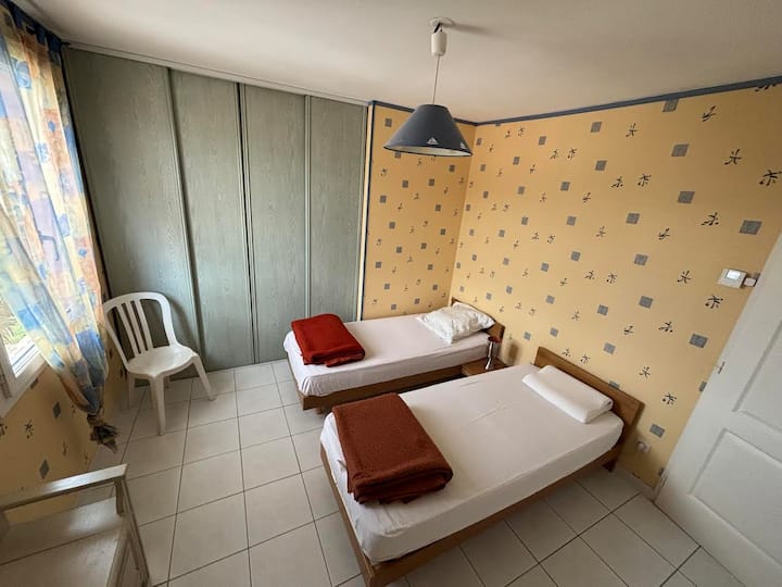 غرفة نوم في الطابق العلوي بسريرين فرديين