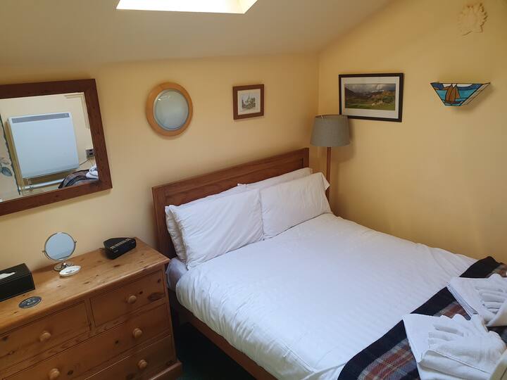 בחדר השינה  יש מיטה זוגית בגודל מלא, מנורת קריאה ותמונות מקומיות, המעניקות תחושה נינוחה ונעימה.